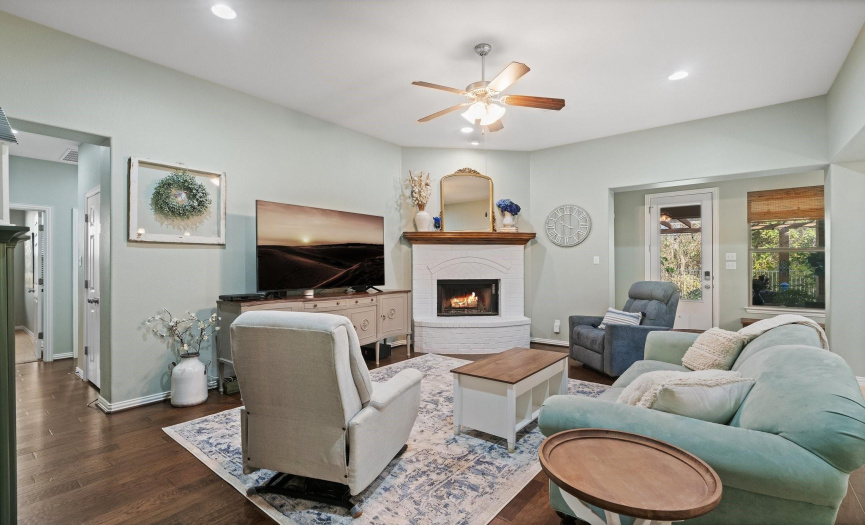 The spacious living room hosts a cozy white painted brick fireplace.