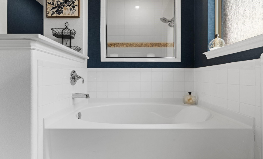 The relaxing soaking tub sits in front of the walk-in shower.