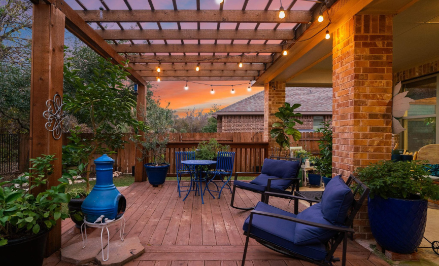 The covered patio extends to a large deck with a custom pergola cover.