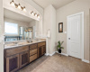 This gorgeous ensuite bath will serve as your daily spa-getaway. Featuring a stylish dual vanity with natural wood cabinetry that gives off authentic Texas vibes. 