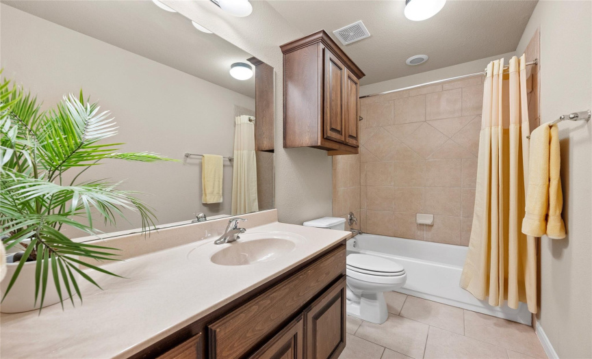 The full secondary bathroom provides a spacious vanity and a shower/tub combo with tasteful tile backsplash. 