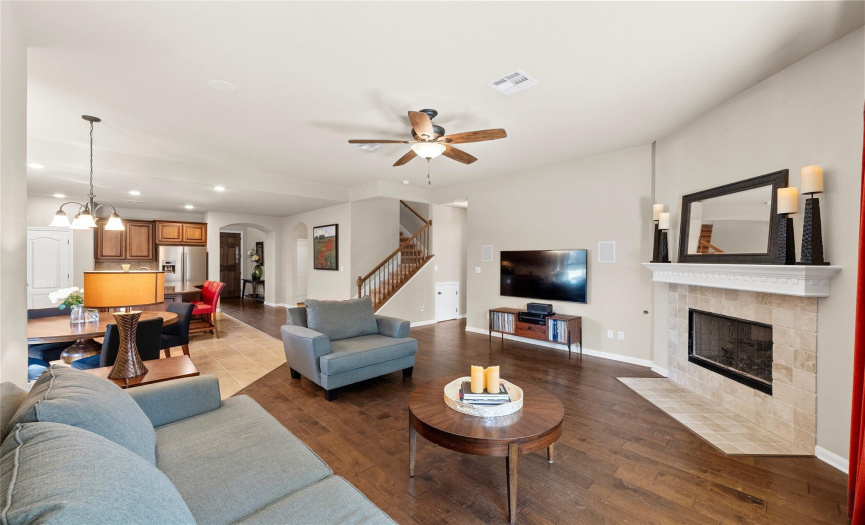 Featuring a gas log fireplace, LED recessed lighting, and a mix of elegant wood floors and tasteful tile. 