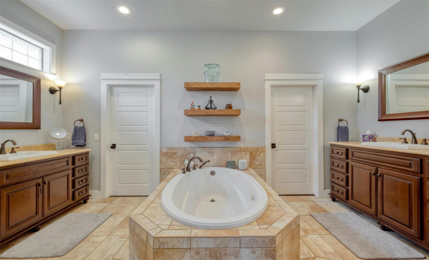 Spacious primary bath suite features his & her closets and vanities. 