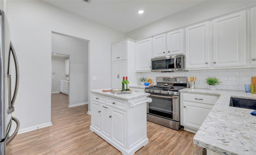 Stainless LG appliances, a useful center island and quartz counters appoint the kitchen.