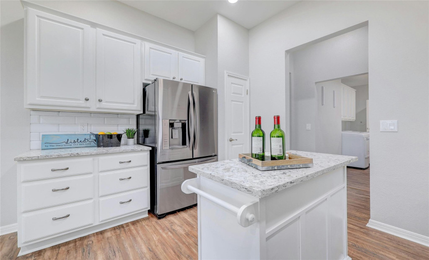 Light, bright white cabinets and tile backsplash in kitchen.