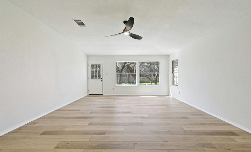 Large living area looking out on large back yard with large oak trees