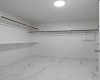 Large Primary walk in closet with a tile floor. 