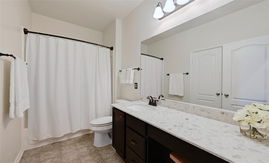 Secondary bathroom with lots of counter space.  Knee hole under cabinet for stool or more storage.  Also has a linen closet across from counter.