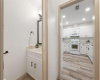 The guest bathroom is located next to the kitchen. The half bathroom offers a nice vanity, a new modern light fixture, new cabinet hardware and a modern framed mirror.