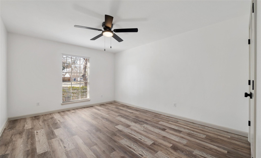The secondary bedroom has the same beautiful flooring, a nice size closet, with 2.5 inch blinds, a modern ceiling fan and a very nice view of the front yard.