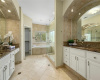 Primary Bathroom with Travertine Tile, Dual Vanity Sinks and Large Walk in Closet