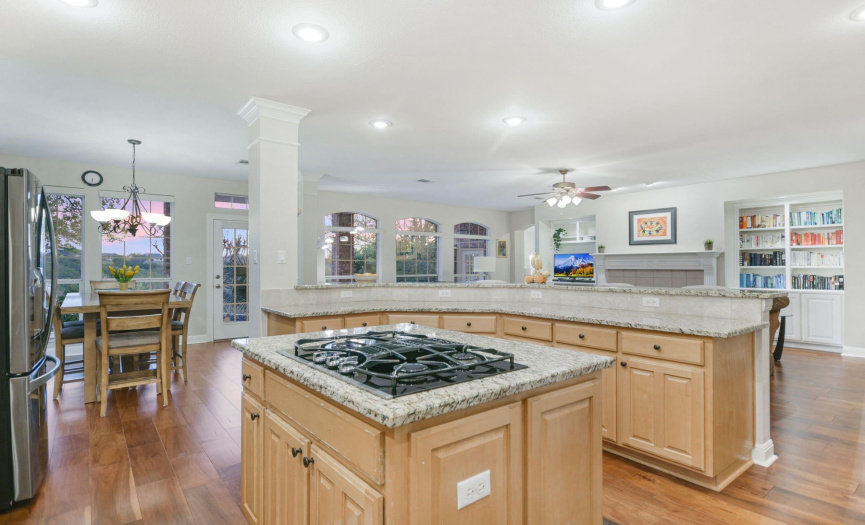 Gourmet island kitchen featuring granite counters and hardwood floors with ample cabinet storage. Kitchen opens to breakfast and family room.