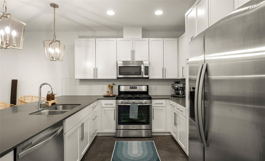 Stainless steel appliances include a gas range, microwave, and dishwasher. 