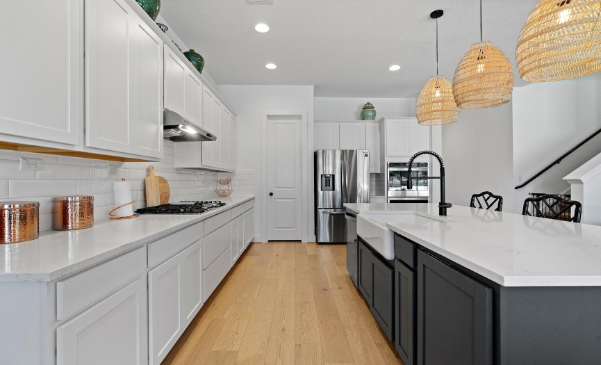 Cooking in this amazing gourmet kitchen is a dream with sleek quartz countertops, stainless steel appliances, plentiful counter space and cabinetry storage, a pantry, and an under-mount farmhouse sink. 
