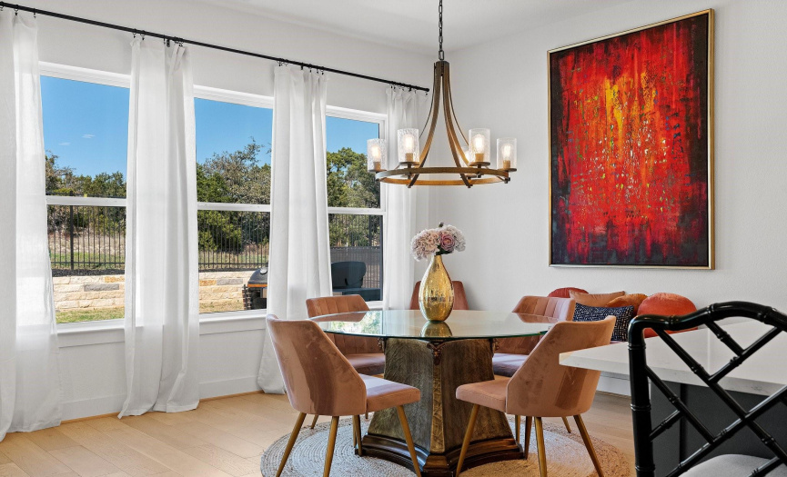 The sunny dining area is nestled alongside a wall of windows with amazing greenbelt views and provides space for a sizable dining table of any shape under a lovely candelabra chandelier. 
