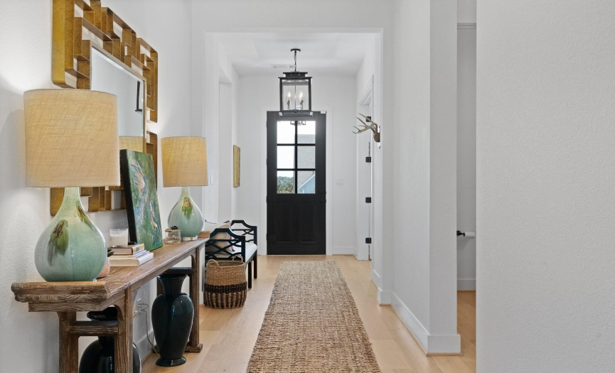 The elegant entryway flows past the home office and secondary bedroom hallway and opens seamlessly into the great room. 