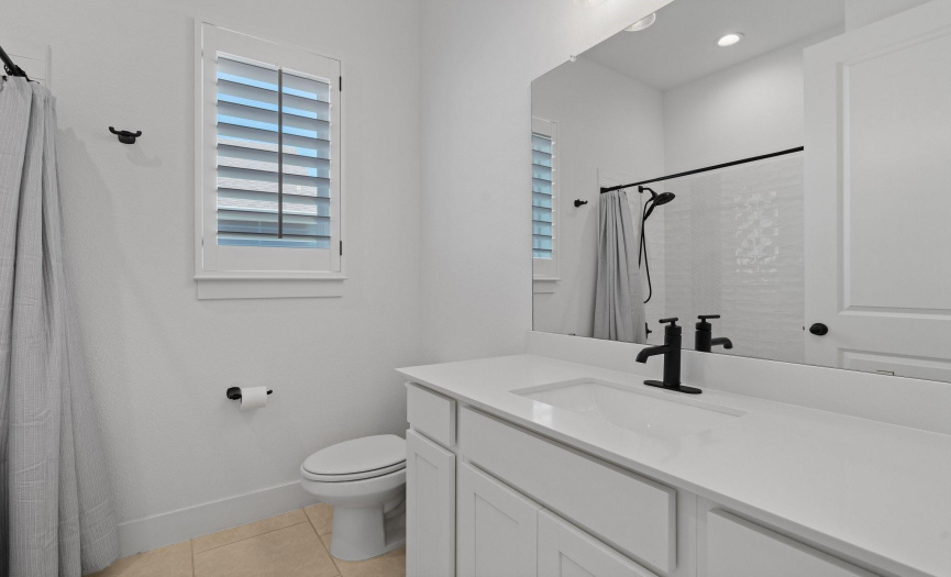 This main floor second full bath is nestled in between the secondary bedrooms and provides a contemporary vanity and a shower/tub combo wrapped in classic subway tile backsplash.