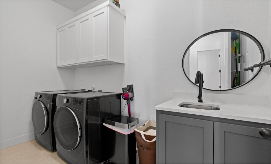 You'll love all the space in this in home laundry room, situated off the mud room. Featuring a vanity with a sink plus convenient storage cabinetry. 