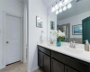 The lovely private ensuite bath provides a dual vanity with beautifully stained cabinetry plus a private commode area. 