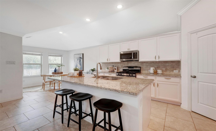 The oversized center island is lined with inviting breakfast bar seating that everyone will want to gather around. 