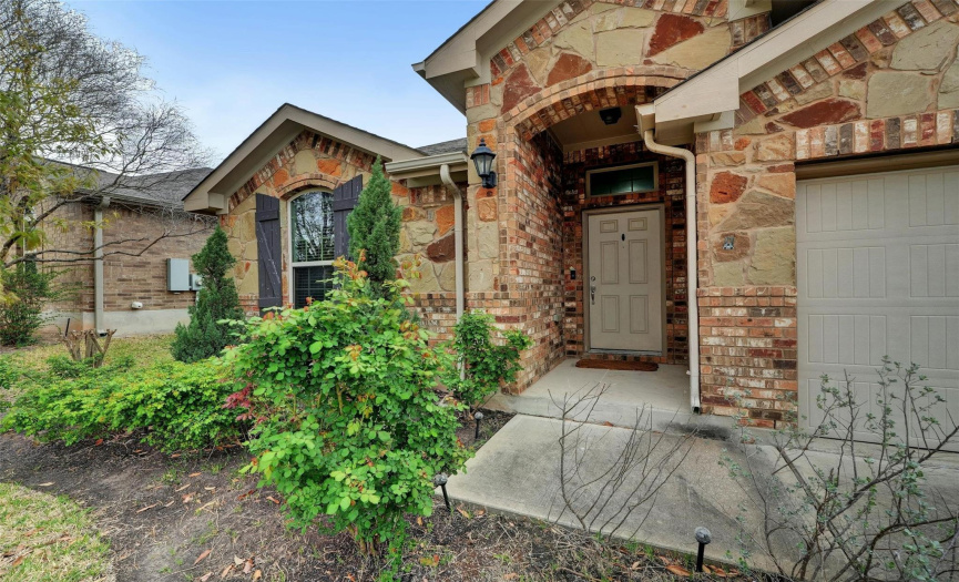 Stunning curb appeal with picture perfect stone masonry, mature landscaping, vibrant young shade trees, and a two-car garage. 