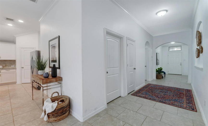 The long and wide entryway flows seamlessly into the main living area through an elegant sweeping archway. 