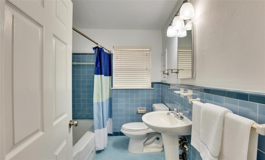 The full bathroom features vintage blue tile throughout..