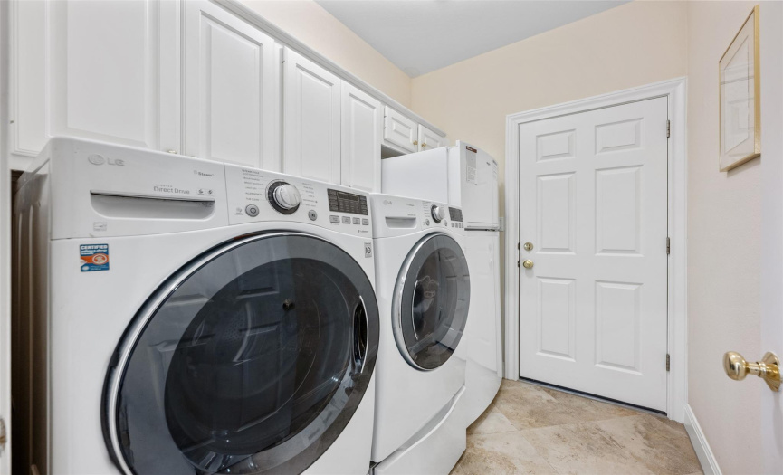 Utility room with lots of cabinetry, washer and dryer, plus refrigerator