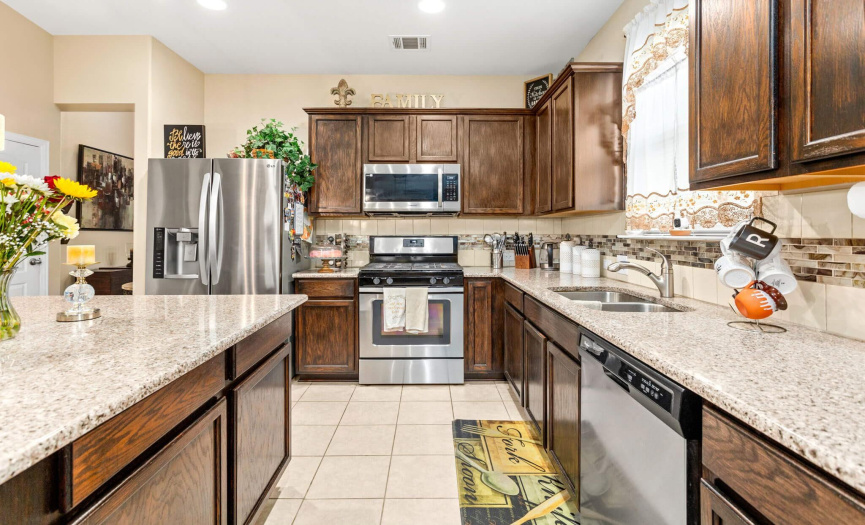 The details in the kitchen are stunning; granite countertops, tile backsplash and sleek stainless steel appliances.
