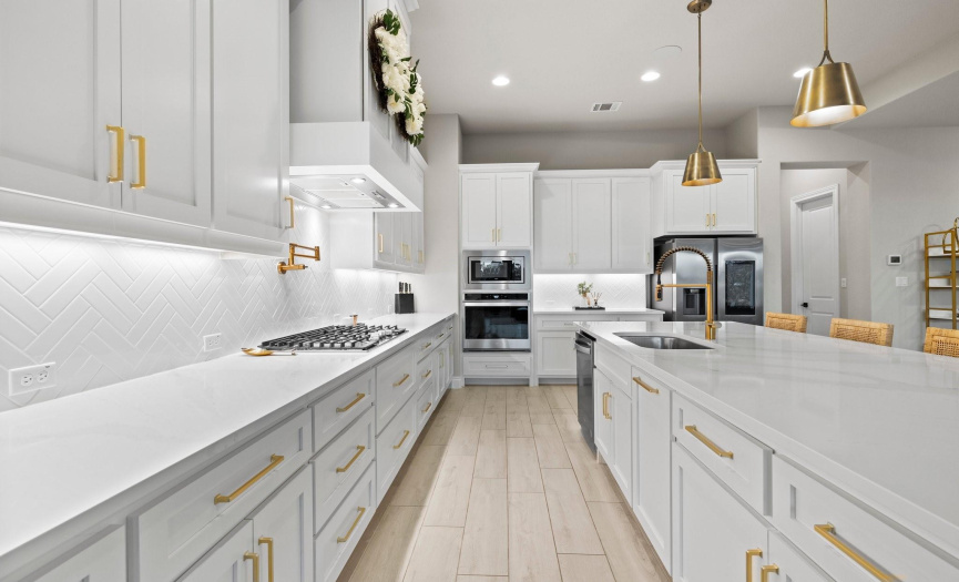 Featuring a chef-grade gas cooktop, a built-in oven and microwave, and ample counter space, this kitchen is perfectly equipped for culinary creations, making it the ideal place to host and entertain guests.