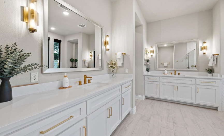 Brass hardware accents add a timeless elegance to the space, complementing the sleek quartz countertops. Framed mirrors offer a touch of sophistication, reflecting the beauty of the meticulously designed surroundings