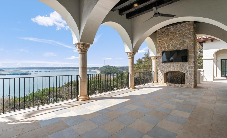 Covered Patio off the main level rooms with graceful arches, gas fireplace, beamed ceilings and ceiling fans provide space for outdoor entertaining on a grand scale