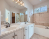 Dual Vanity, Soaking Tub and Separate shower in Primary Bathroom with upgraded Travertine flooring and wall surrounds