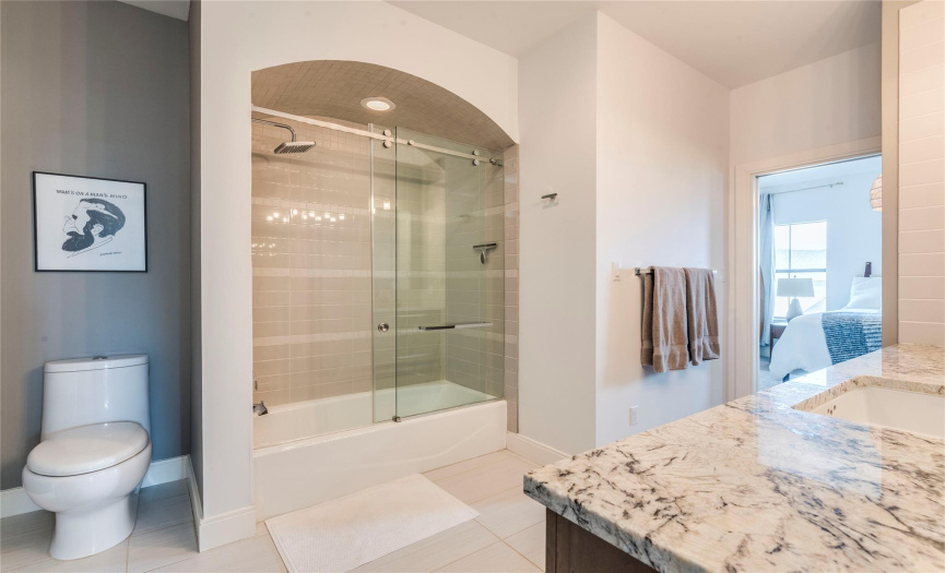secondary bathroom with glass door walk in shower with tub. 