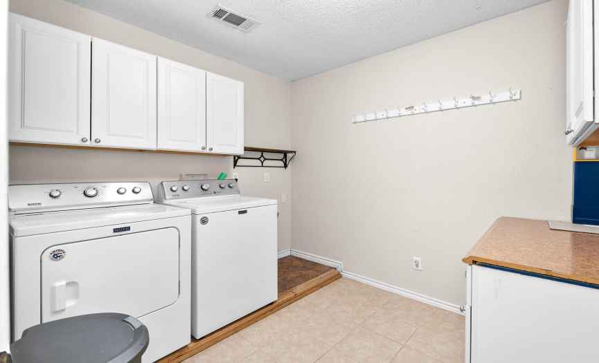 Laundry room includes washer and dryer, as well as ample storage. 