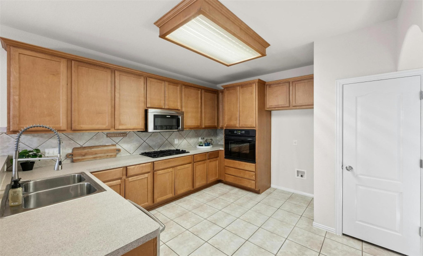 Discover a spacious kitchen boasting a breakfast bar, lots of storage, and a gas cooktop.