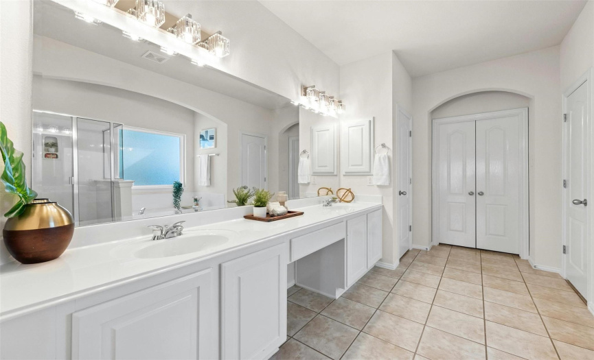 The large, en-suite master bath features a dual vanity with a sitting area. 