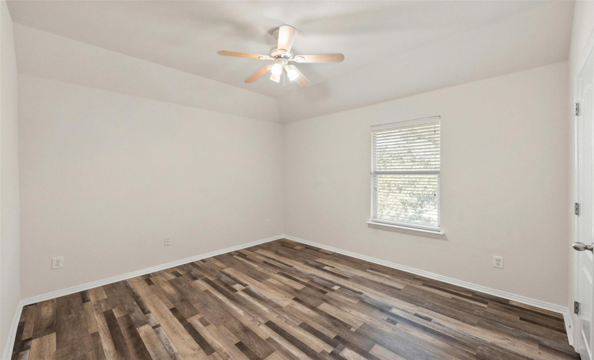 Another well-sized bedroom, with vinyl plank flooring and a ceiling fan.