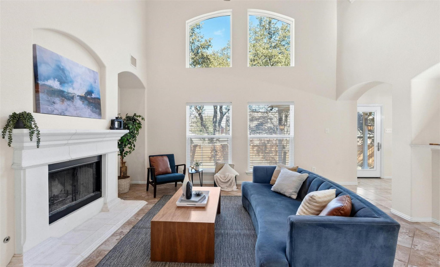 Relax in the spacious living room, featuring large windows framing the backyard views.