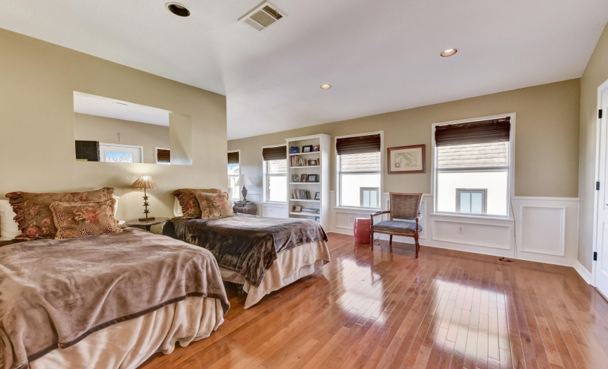 Another enormous bedroom with gleaming wood floors an built-in bookcase
