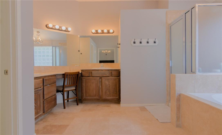 Primary bathroom with double vanities and his and hers closets