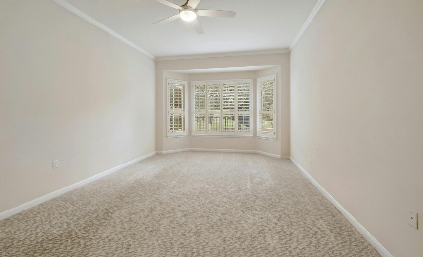 Main Bedroom is comfortably carpeted with bay window, 10' ceilings and crown molding.