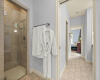 A walk-in shower with two shower heads is also behind the pocket door.