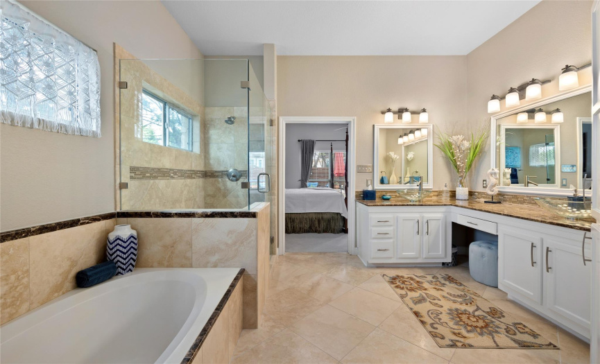 A stunning walk-in shower, garden bathtub, and his and hers sinks.
