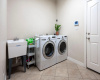 Large laundry room with sink and equipped for stackable washer and dryer as well.