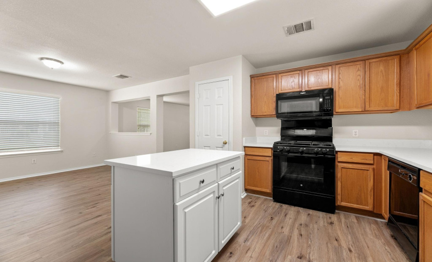 Kitchen features a center island w/plenty of storage, gas range, built in microwave, and pantry.