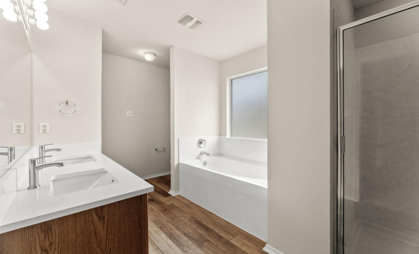 The primary en suite bathroom updates include new vinyl plank flooring, quartz countertop, and Moen faucets.