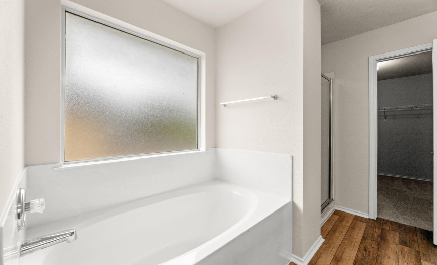 Primary bathroom features a relaxing garden tub and separate walk-in shower.