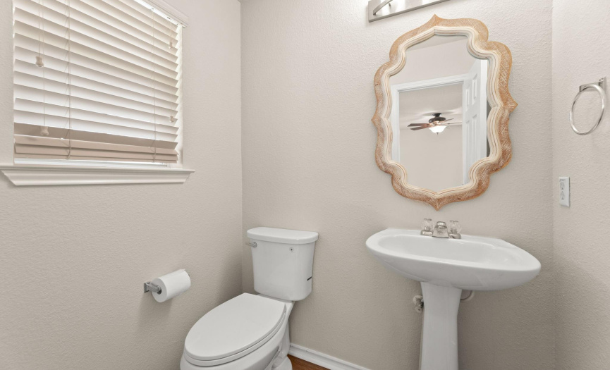 The half bath has been updated with a new mirror and light fixture, and is located right off the entryway.