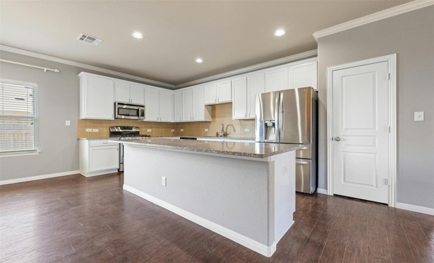 Premium upgrades include plentiful cabinetry with tall upper cabinets, plus granite countertops and SS appliances. 